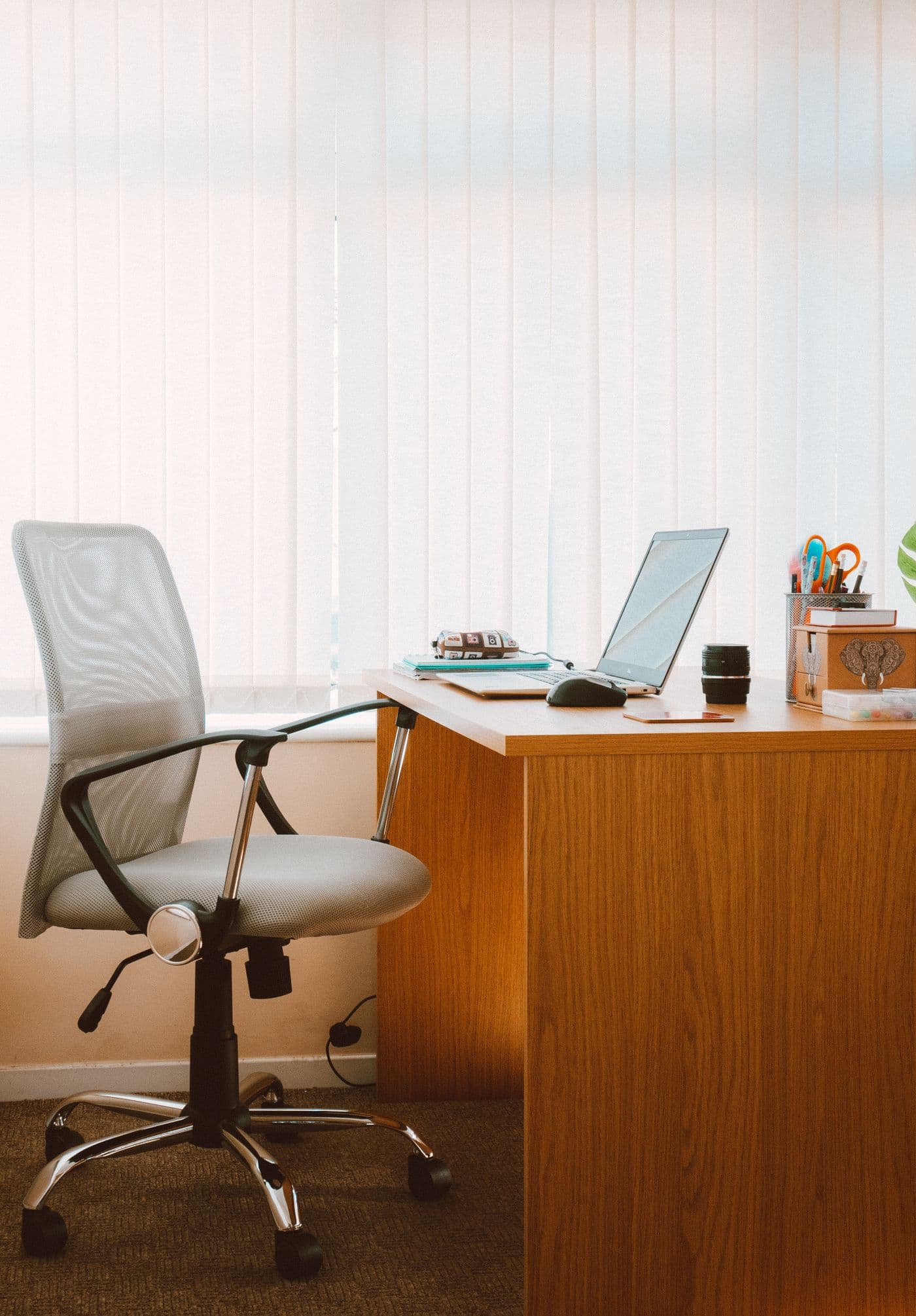 Clean private workspace with a desk and chair beside a bright window