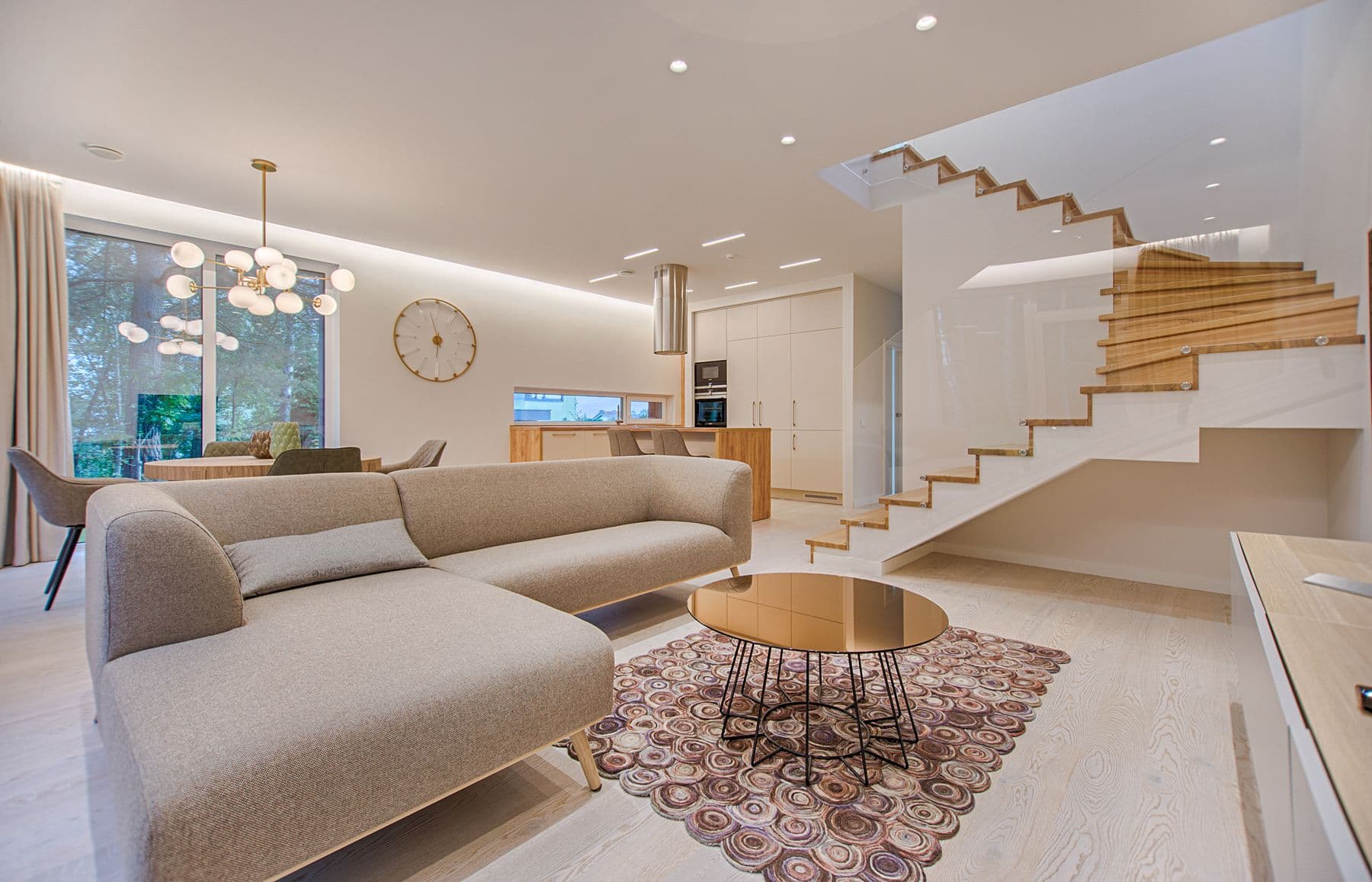 Bright, freshly cleaned living room with a staircase and large windows