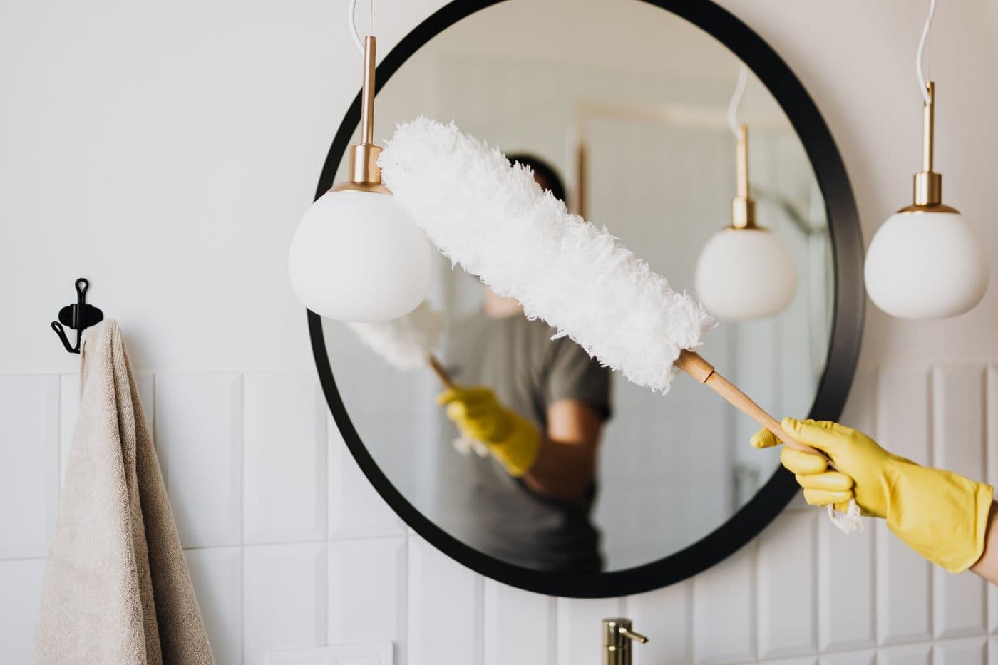 Detailed dusting of a bathroom mirror and light fixtures